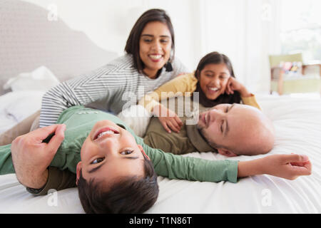 La famiglia felice coccole sul letto Foto Stock