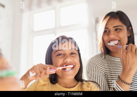 Ritratto felice madre e figlia spazzolare i denti in bagno Foto Stock