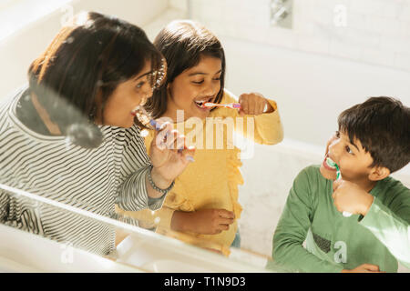 Madre e bambini spazzolare i denti in bagno Foto Stock