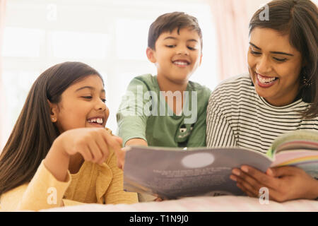 Madre e bambini libro di lettura Foto Stock