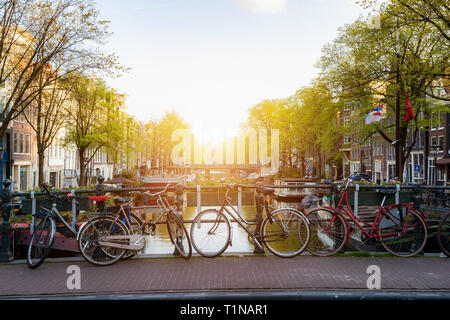 Moto su canal Amsterdam città in Paesi Bassi con vista sul fiume Amstel durante il tramonto. Foto Stock