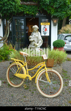 Giallo nel Lusso Huffy bicicletta parcheggiata di fronte una galleria d'arte a Kennebunkport, Maine, Stati Uniti d'America. Foto Stock