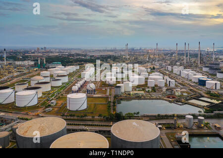 Vista aerea dell'olio serbatoio di stoccaggio con la raffineria di petrolio di sfondo, olio impianto di raffineria di notte. Foto Stock