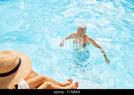 Uomo maturo nella soleggiata piscina estiva Foto Stock