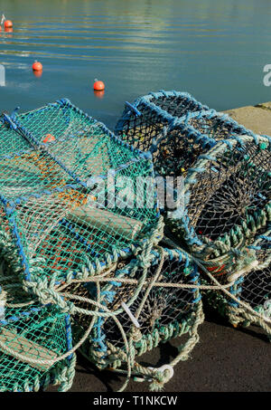 Una pila di aragosta e granchio pentole sul porto di Portpatrick, Dumfries and Galloway, Scozia Foto Stock