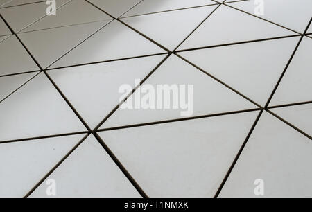 Parete futuristico di triangoli metallici con bordi neri. liscia sfondo geometrico. basso angolo di visione Foto Stock