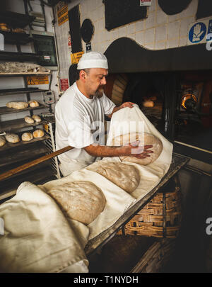 La produzione giornaliera di pane cotto con forno a legna con il metodo tradizionale. Foto Stock