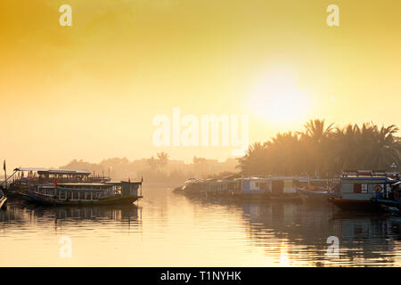 Luce dorata sul fiume Thu Bon di Hoi An, che mostra barche silhouette Foto Stock