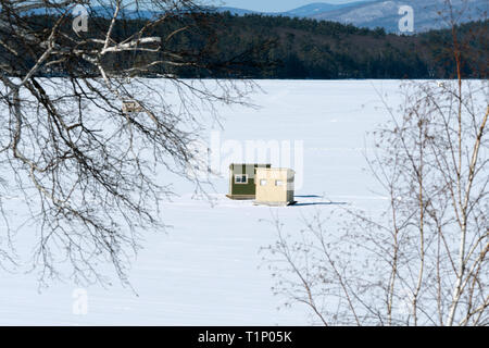 Portable pesca sul ghiaccio bob-case sulla coperta di neve Lago Winnipesaukee vicino White Mountains del New England. Foto Stock