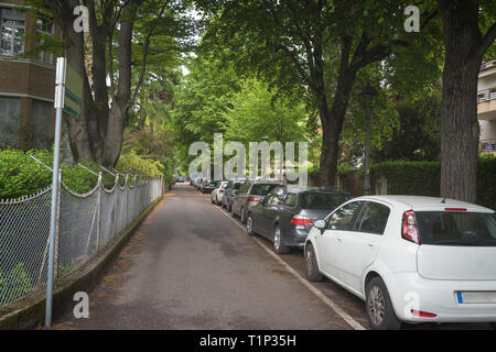 Suburban strada residenziale con moderne case di mattoni e di automobili parcheggiate lungo la strada Foto Stock