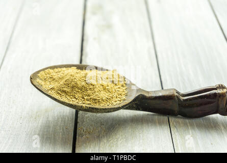 Cucchiaio con la Kava Kava radice in polvere sul tavolo di legno Foto Stock