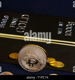 Bitcoin cryptocurrency e barra color oro su sfondo nero Foto Stock