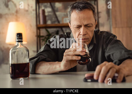 Deluso martoriata vecchio uomo avendo problemi di vita e l'utilizzo di alcool Foto Stock