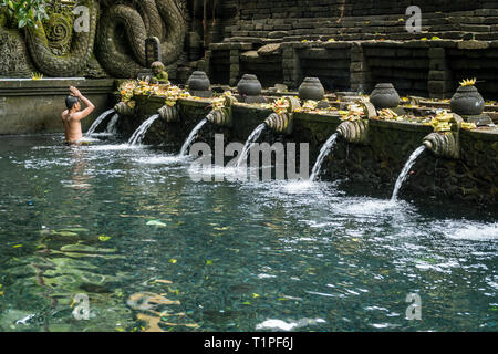 Bali, Indonesia - 22 gennaio 2019: il giovane uomo che prega nella primavera sacra di acqua pura Tirta Empul temple a Tampa, Bali, Indonesia. Foto Stock