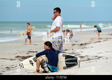 HOLMES BEACH, Anna Maria Island, FL / USA - Ottobre 4, 2013: surfisti sulla spiaggia prendendo una pausa e guardare i loro compagni di surfers. Foto Stock