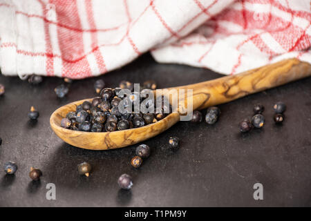 Sacco di tutta la secca di bacche di ginepro Semi sul grigio pietra Foto Stock