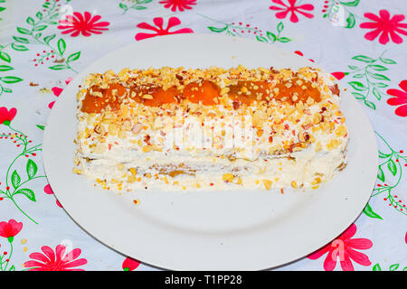 Torta con crema, albicocca e spolverati con dadi Foto Stock