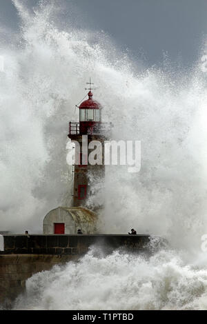 Porto, Portogallo - 7 Febbraio 2016: persone rischiare la vita durante una tempesta di mare nel vecchio faro (farolim de Felgueiras) presso la foce del fiume Dou Foto Stock