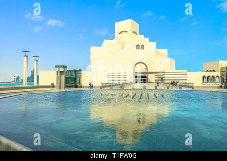 Doha, Qatar - 16 Febbraio 2019: il Museo di Arte Islamica, popolare attrazione turistica lungo la Corniche nella città di Doha riflettendo sulla fontana di acqua in un soleggiato Foto Stock