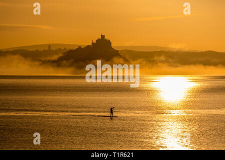 Penzance, Cornwall, Regno Unito. 28 Mar, 2019. Regno Unito Meteo. Paddleboarders erano fuori a 5am questa mattina per renderlo in tutto il mare a Mounts Bay per il tramonto su St Michaels Mount. Credito: Simon Maycock/Alamy Live News Foto Stock