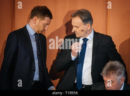 28 marzo 2019, in Sassonia, Trebendorf: Sassonia il primo ministro Michael Kretschmer (l-r, CDU) sorge accanto a Waldemar Locke, Sindaco di Trebendorf e Reinhard Bork, Sindaco di Schleife, nel "Gasthaus Zur Erholung' in Mühlrose in Lusazia. Il contratto per la nuova sistemazione del villaggio tra i comuni di Trebendorf e Schleife e la società energetica Leag è stato firmato. Mühlrose è uno degli ultimi villaggi del distretto Lusatian per dare modo a carbone marrone, che è quello di essere dragati all inizio del 2030s. Lausitz Energie Bergbau AG si aspetta un volume di produzione di 150 milioni di tonn Foto Stock