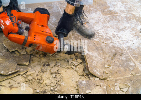 Preparazione di riparare il bagno. Rimozione di vecchie piastrelle con jackhammer Foto Stock