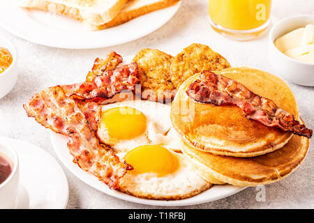 Una sana colazione Americana completa con uova pancetta pancake e Latkes, il fuoco selettivo. Foto Stock