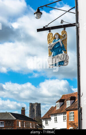 L'Angelo pub segno di fronte alla Piazza del Mercato con San Pietro e di san Paolo la chiesa parrocchiale per la parte posteriore. Lavenham village, Suffolk, Inghilterra, Regno Unito. Foto Stock