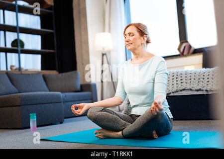 Tranquilla bella donna meditando con gli occhi chiusi Foto Stock