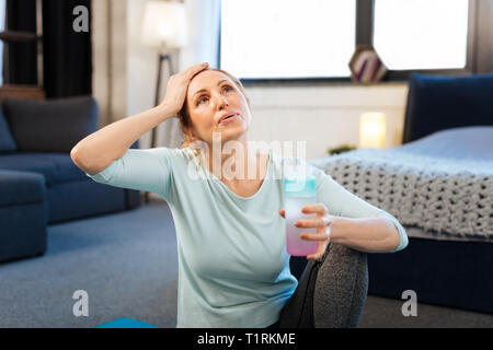 Concentrato di bella donna con capelli legati a fare gli esercizi Foto Stock