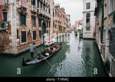 Venezia, Italia - 5 Maggio 2018: un gruppo di turisti che viaggiano in gondola attraverso i suggestivi canali di Venezia, Italia Foto Stock