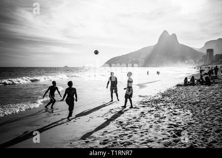 RIO DE JANEIRO, Brasile - 24 febbraio 2015: un gruppo di brasiliani giocando sulla riva della spiaggia di Ipanema, con il famoso Dois Irmaos montagna dietro di loro Foto Stock