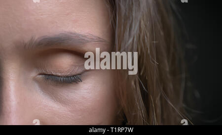 Primo piano semi-faccia scattare di giovani piuttosto caucasian brunette faccia femmina marrone con occhio essendo chiuso nella parte anteriore della fotocamera Foto Stock