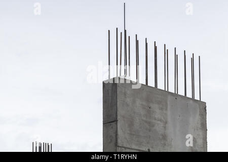 Parete in cemento con i raccordi di acciaio sotto il cielo luminoso sullo sfondo Foto Stock