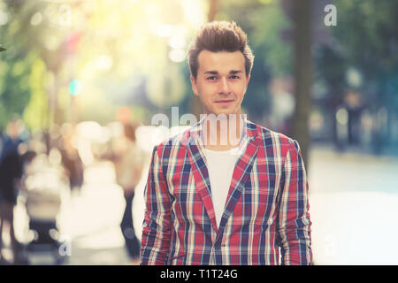 Ritratto di bello sorridente uomo elegante in plaid blazer in città. Street style concept. Effetto vintage. Foto Stock