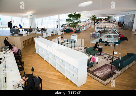 Nuovo Helsinki Biblioteca centrale Oodi interni. Luminosa e spaziosa moderna architettura del nord. Gli scaffali, lo spazio di lavoro. Le persone leggere, lavorare Foto Stock