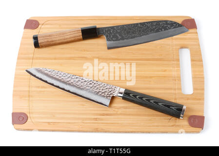 Due top grade coltelli giapponesi sul bambù tagliere, isolato Foto Stock