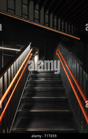 Aumento di metallo nera scalinata con corrimano di colore arancione e bianco integrato strisce di illuminazione. Sentralen, Oslo, Norvegia. Architetto: Atelier Oslo & Kima Arkite Foto Stock