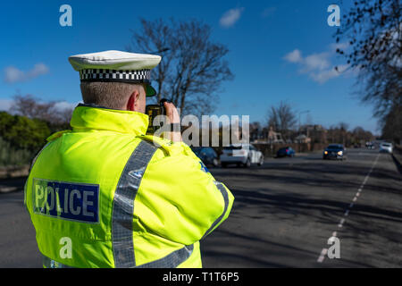 Il traffico funzionario di polizia tenendo un radar della velocità telecamera a un urbano di controllo velocità checkpoint in Edimburgo, Scozia UK Foto Stock