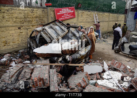 I residenti del Kashmir sono visto in piedi davanti a un veicolo danneggiato dopo un esplosione. Relazioni ha detto che il panico afferrata in Alochi Bagh area di Srinagar quando un misterioso blast ha avuto luogo nelle vicinanze dell'esercito indiano del camp nella zona. Una casa e un veicolo parcheggiato sono state danneggiate a causa dell'impatto dell'esplosione. Foto Stock