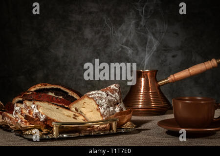 Caffè appena macinato infuso in un turco su uno sfondo di legno Foto Stock