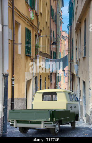 Piccolo appartamento bed carrello parcheggiato in uno stretto vicolo tra alti edifici antichi con biancheria stesa ad asciugare attraverso la pista in una città storica Foto Stock