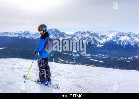 Giovane sciatore permanente al bordo di una gamma di montagna al Lago Louise al Canadian Rockies di Alberta, Canada. Foto Stock