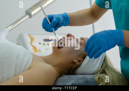 Bella donna avente un cosmetico del viso trattamento scrub. Anti-invecchiamento, cura della pelle e lo stile di vita di lusso concetto. Foto Stock