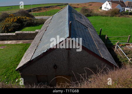 Il vecchio blocco servizi igienici sotto i negozi sulla strada principale in Ogmore dal mare, presto per essere demolita per far posto alla nuova village hall su questa terra. Foto Stock