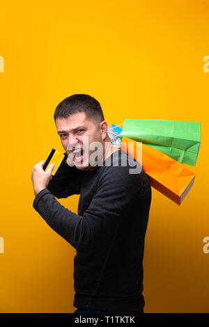 Foto di un uomo con la carta di credito e multi-colore di borse per lo shopping Foto Stock