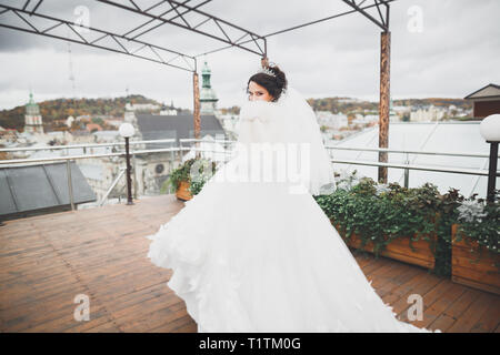 Bella sposa la filatura con abito perfetto nella città. Foto Stock