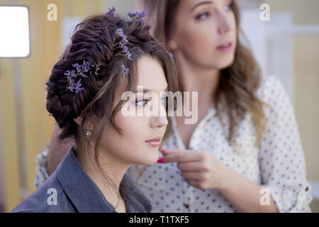 La stilista truccatore facendo il trucco e capelli in un salone di bellezza. Professionale di make-up, maestro di creazione dell'immagine. Foto Stock