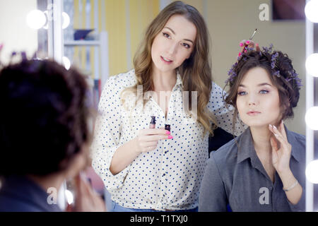 La stilista truccatore facendo il trucco e capelli in un salone di bellezza. Professionale di make-up, maestro di creazione dell'immagine. Foto Stock