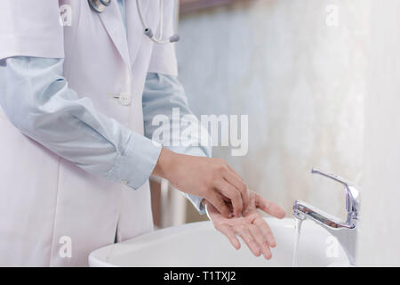 Medico donna lavaggio a mano nel lavandino con schiuma di sapone Foto Stock